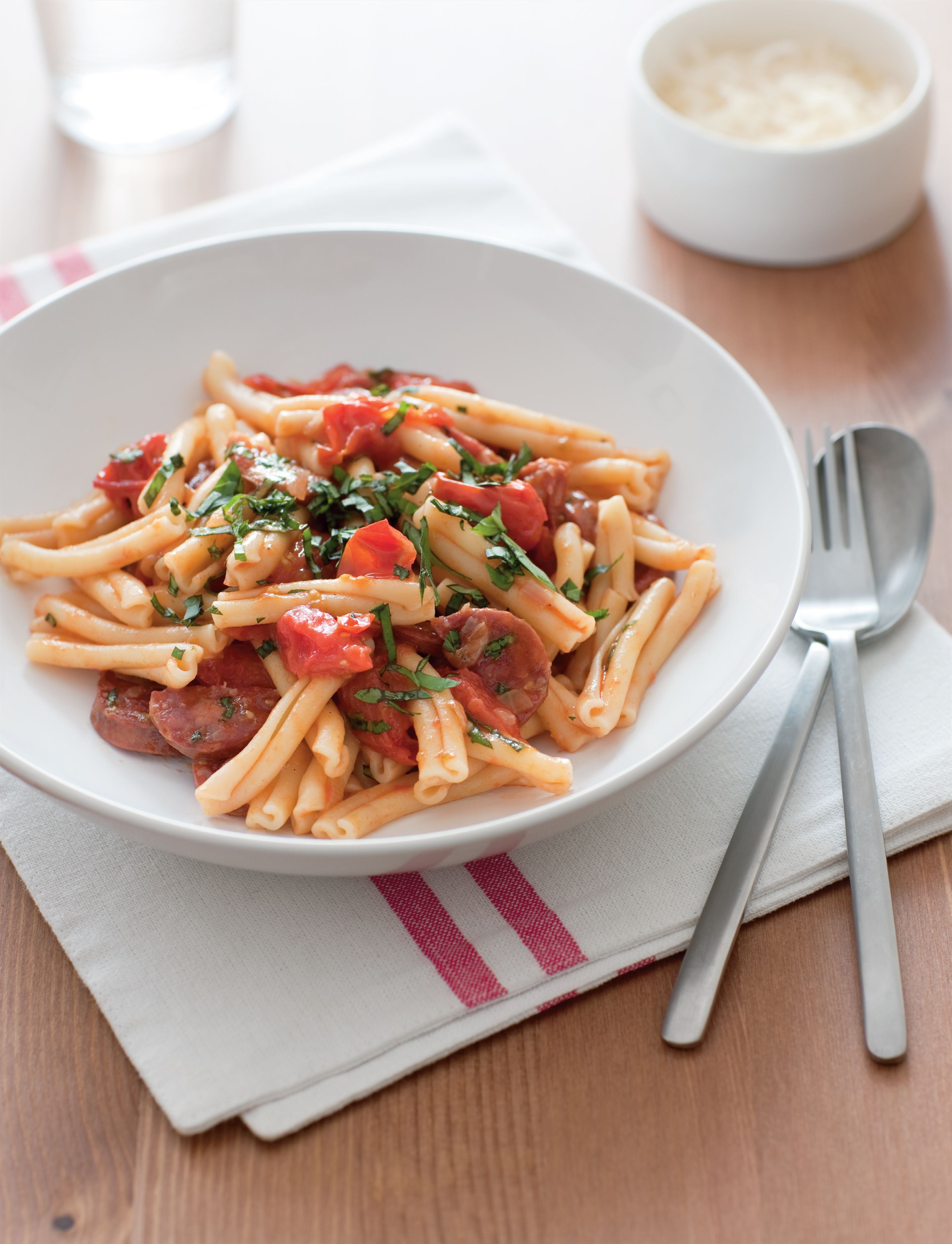 Pasta with cherry tomatoes, spicy salami and basil