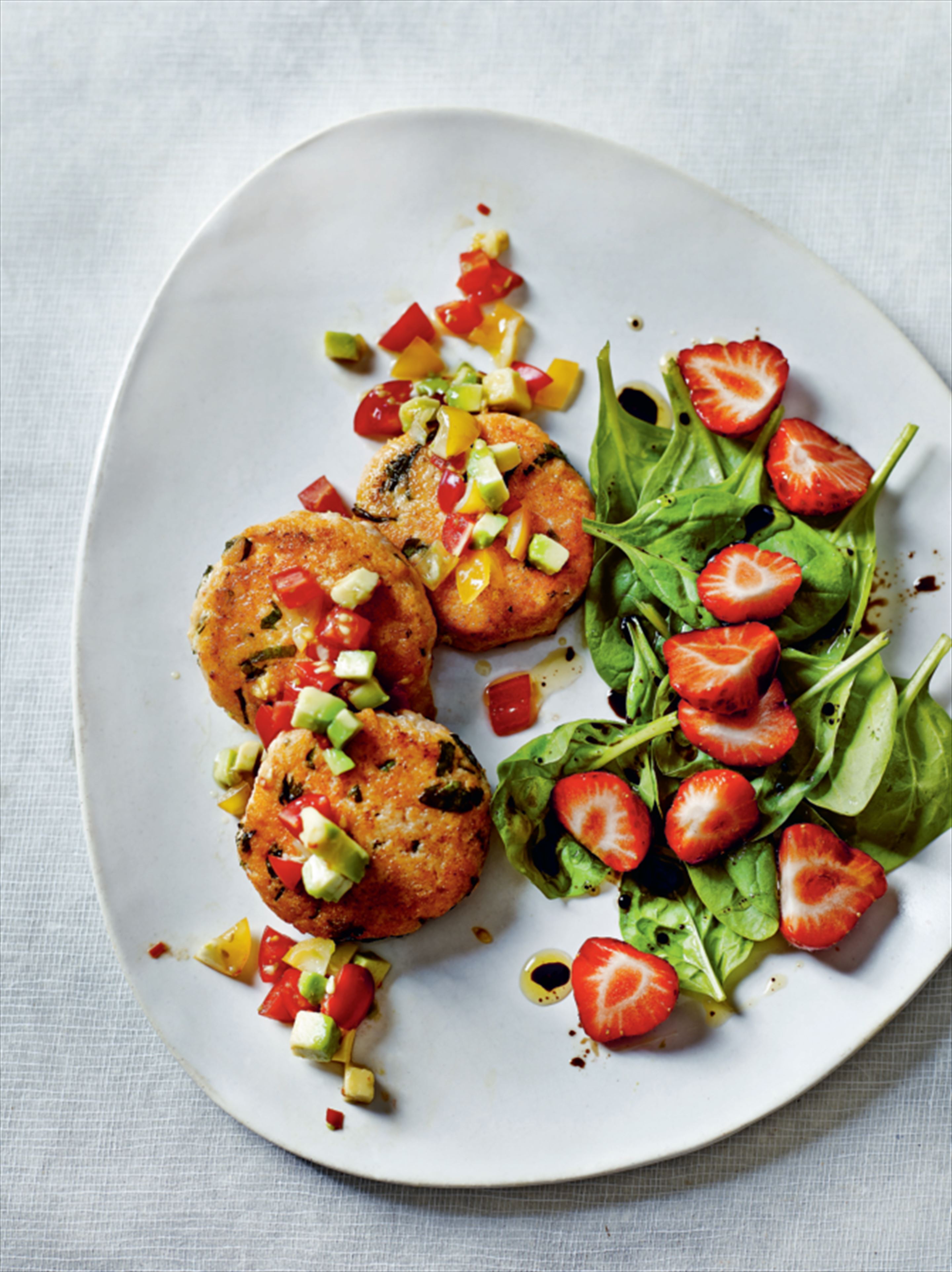 Herbed salmon burgers with avocado salsa and spinach-strawberry balsamic salad