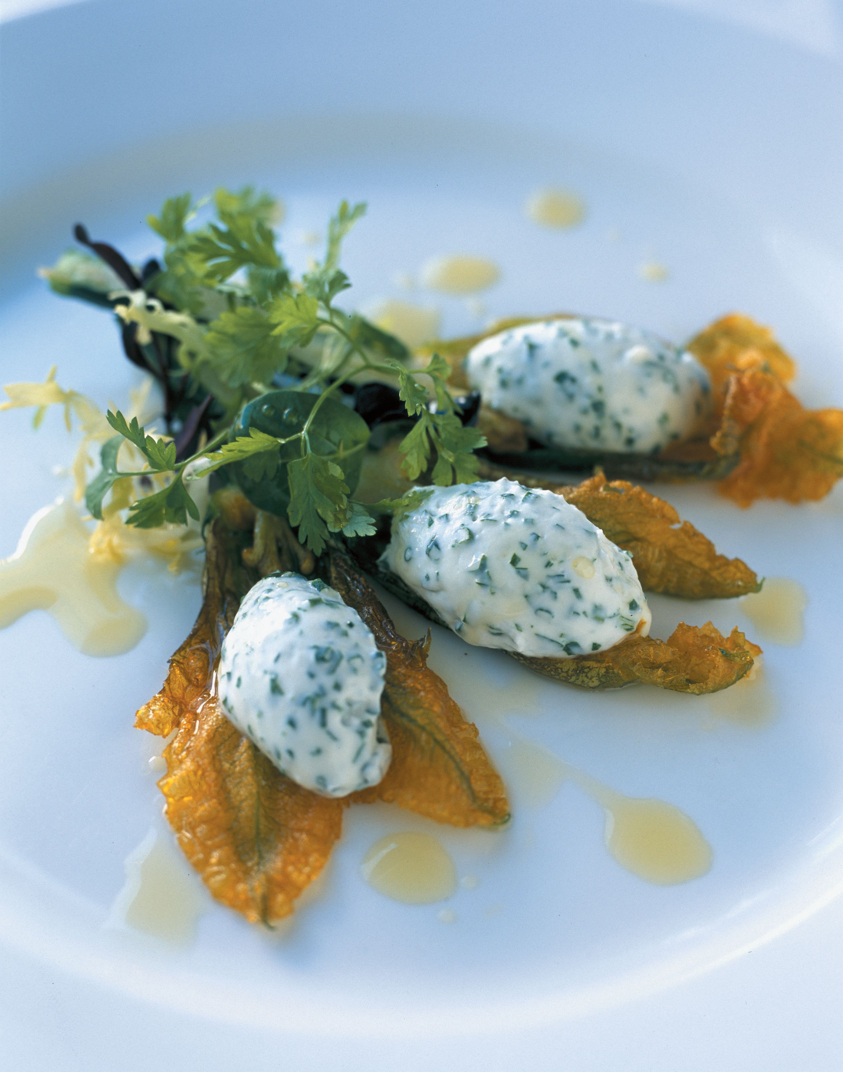 Deep-fried zucchini flowers with chive and shallot-whipped goat’s curd and a herb salad